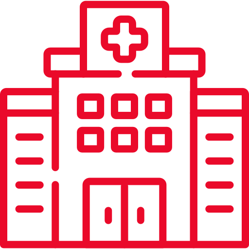 Red outline icon of a hospital building with a cross symbol above the entrance and large double doors in the center. The building has multiple windows and a symmetrical design.